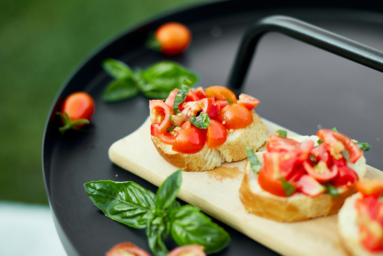 Tomato and basil toasts on a wooden board