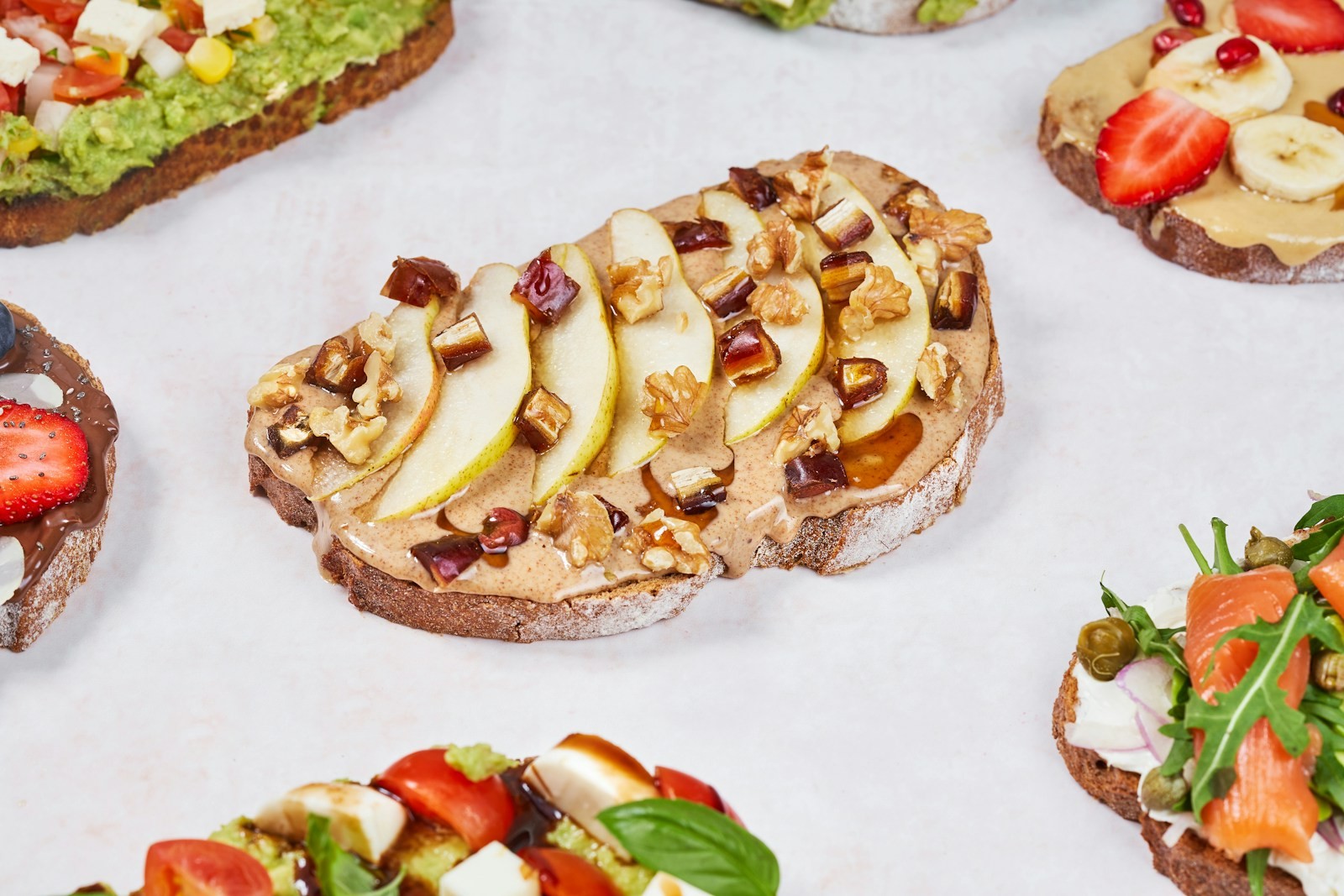 Toast topped with sliced pear, chopped nuts and a creamy spread