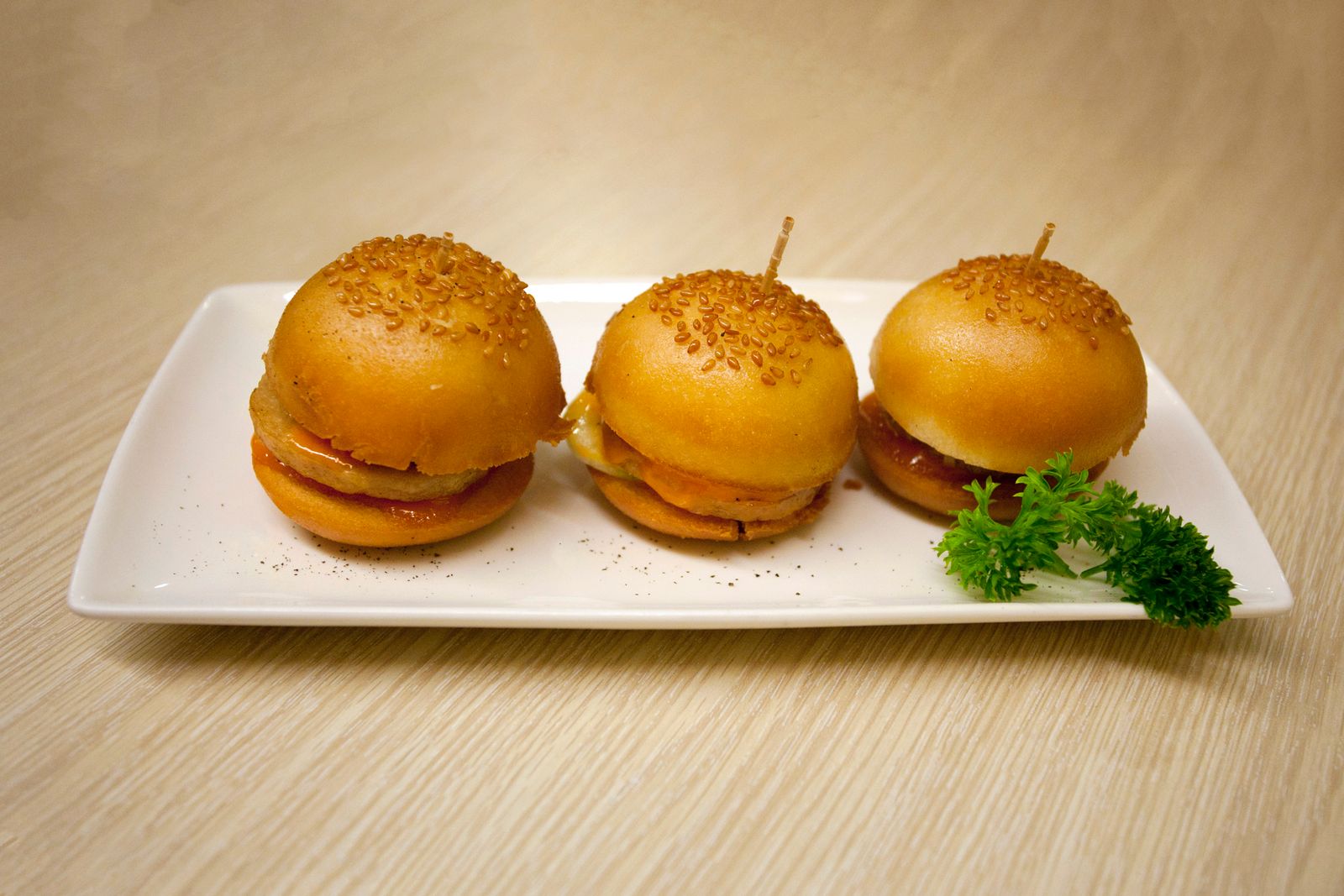 Three mini breakfast sliders on a white plate