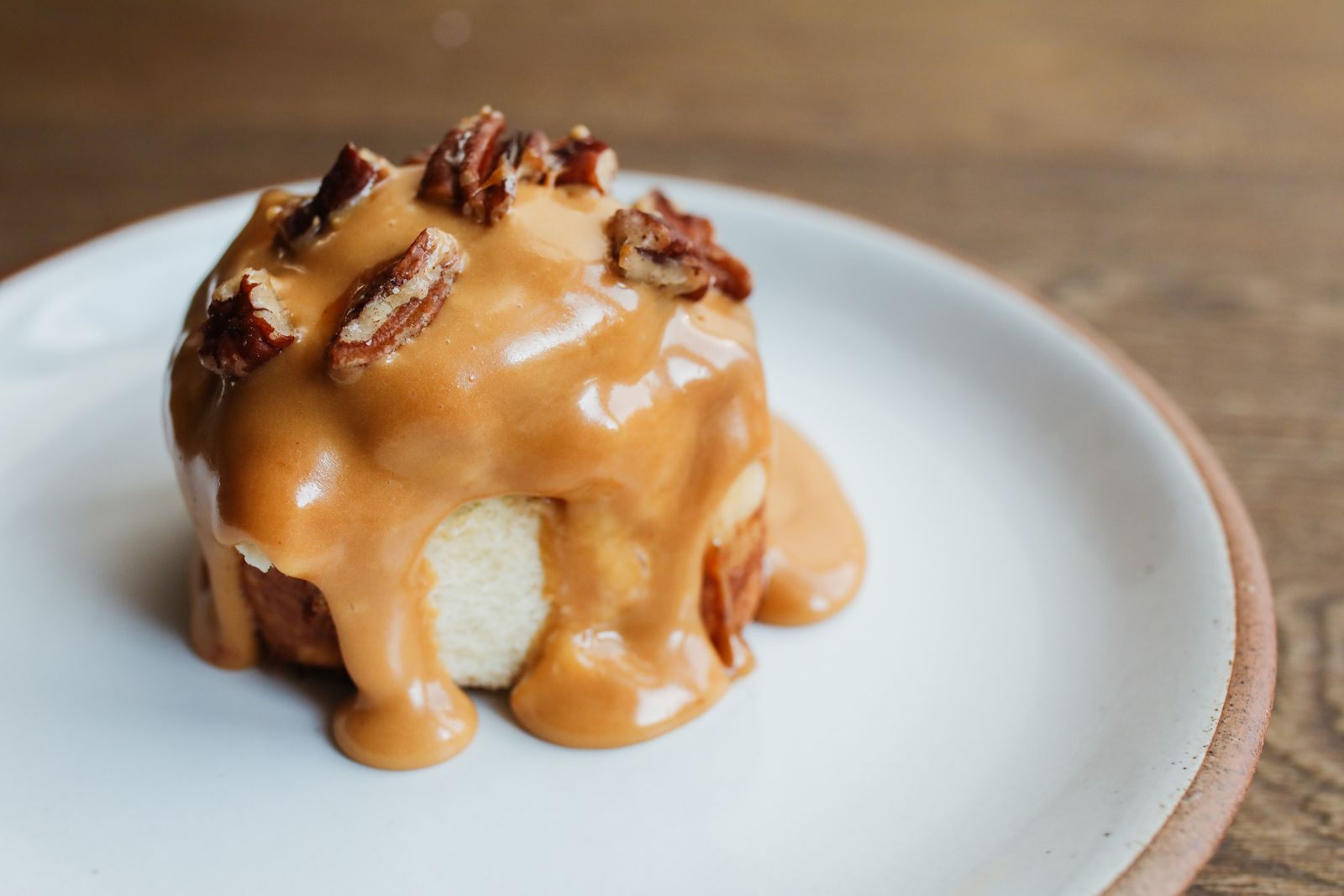 Sticky caramel pecan bun dripping with sauce