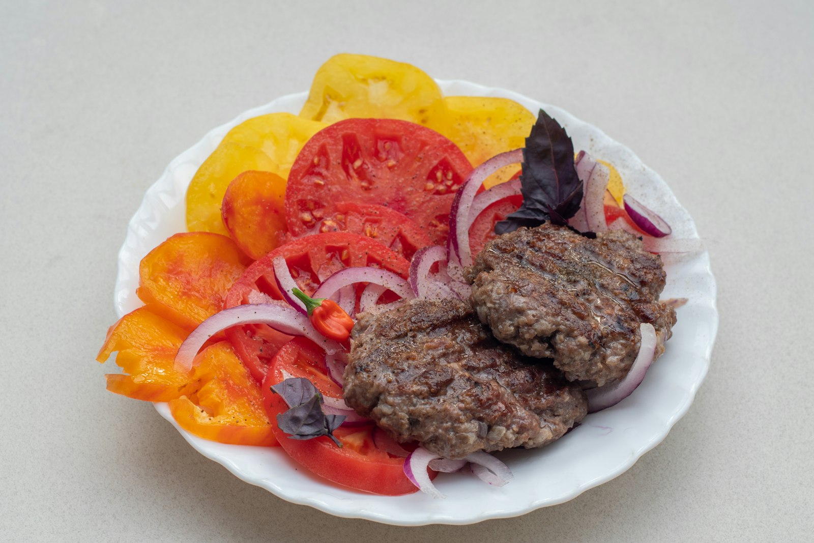 Hamburger steak patties with tomato and onion
