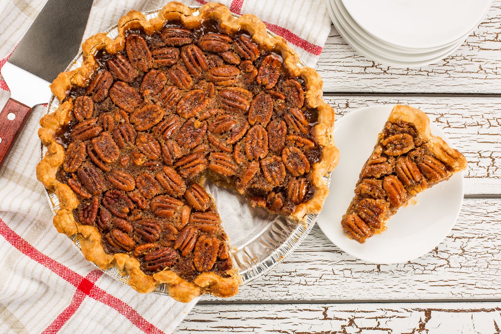 Pecan pie with a crimped edge and one slice cut