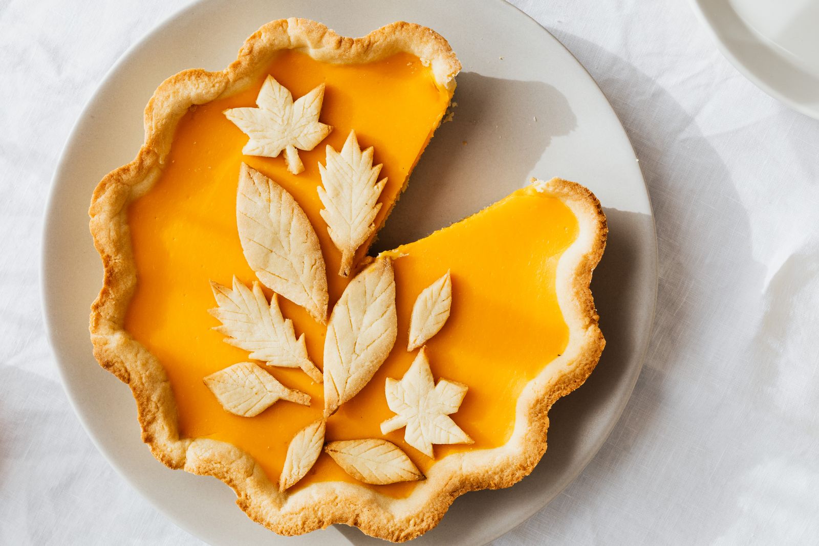 Sliced pumpkin pie with pastry leaves on the edge
