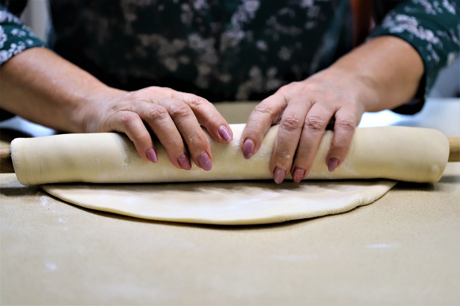 Rolling out pie dough on a floured counter