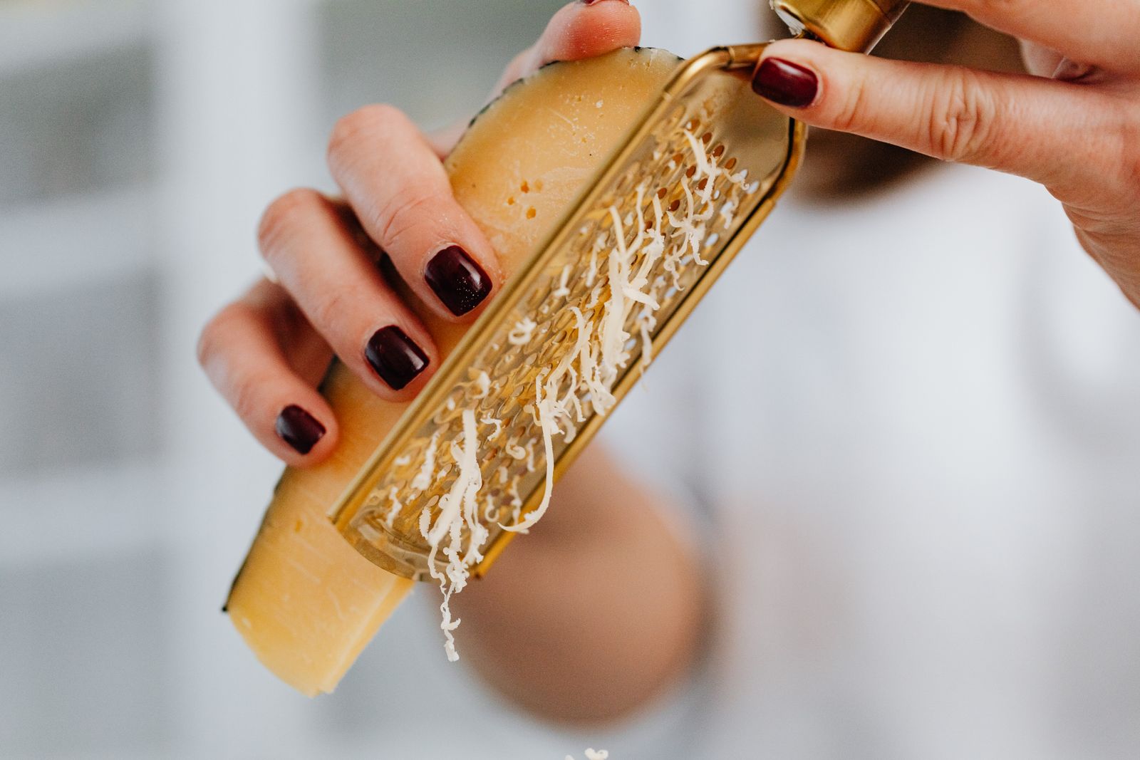 Hands grating a wedge of real Parmesan