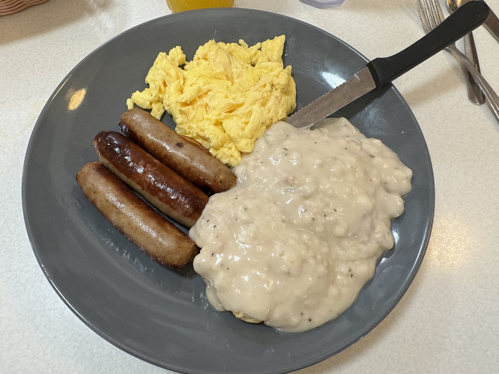 Southern breakfast plate with sausage links, scrambled eggs and gravy
