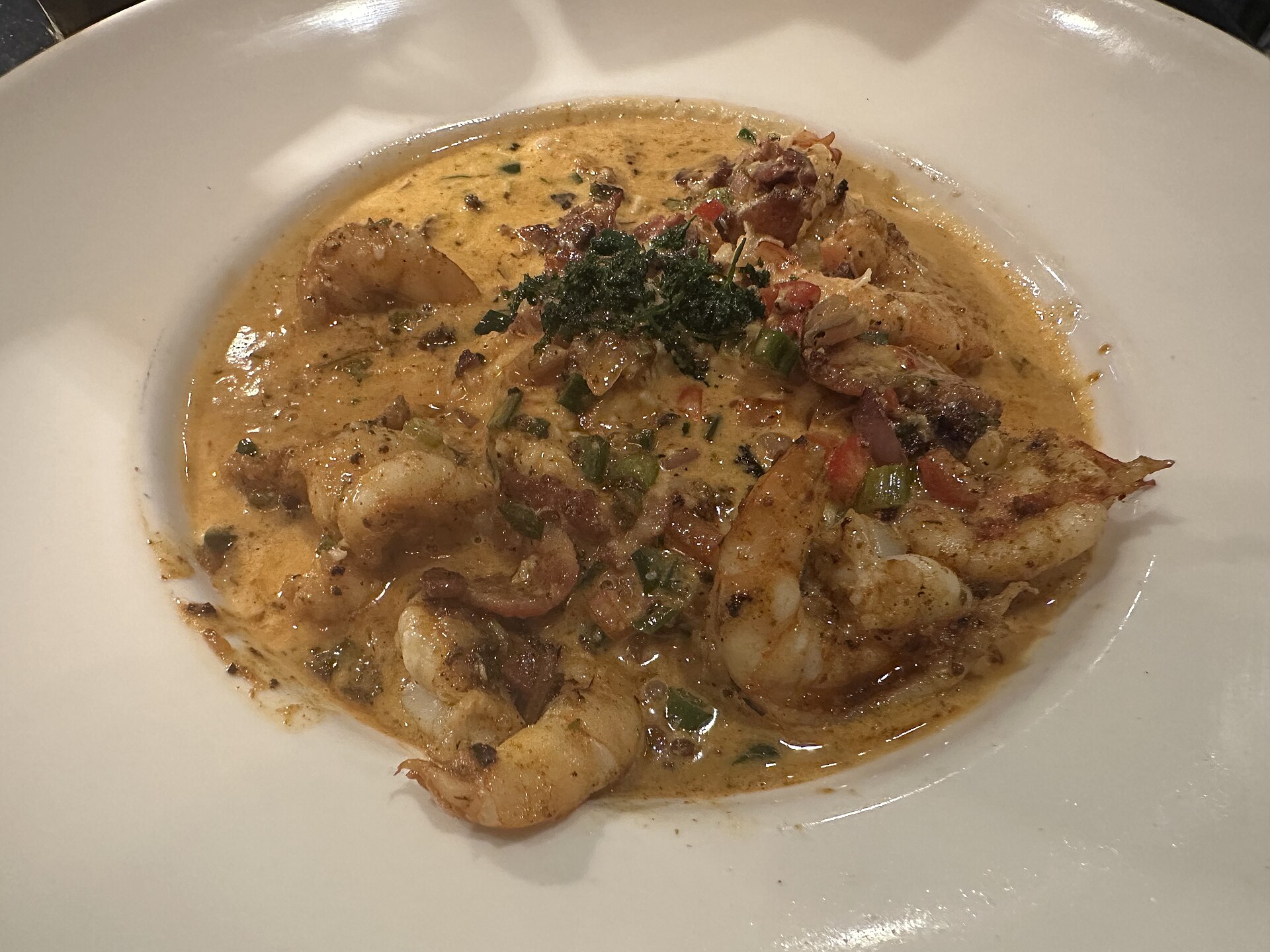 Shrimp and grits in a creamy sauce in a white bowl