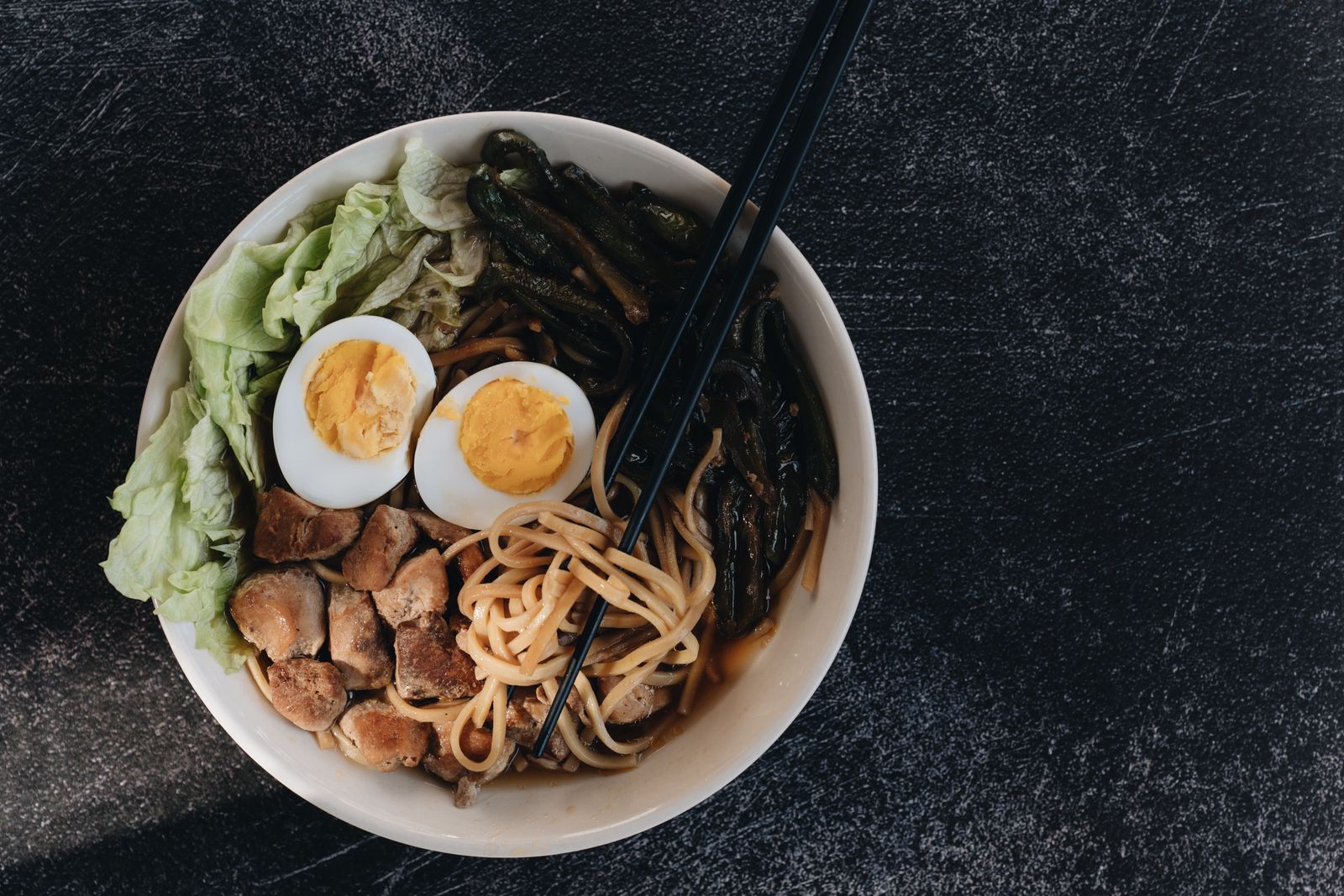 A bowl of ramen noodles topped with soft boiled eggs