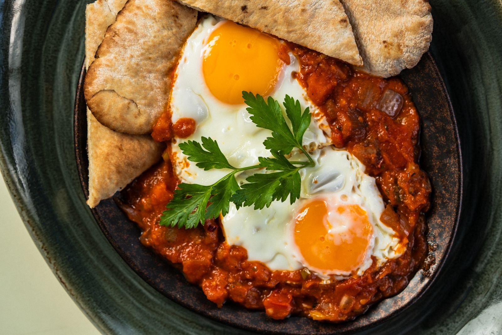 Shakshuka with eggs in tomato sauce and bread