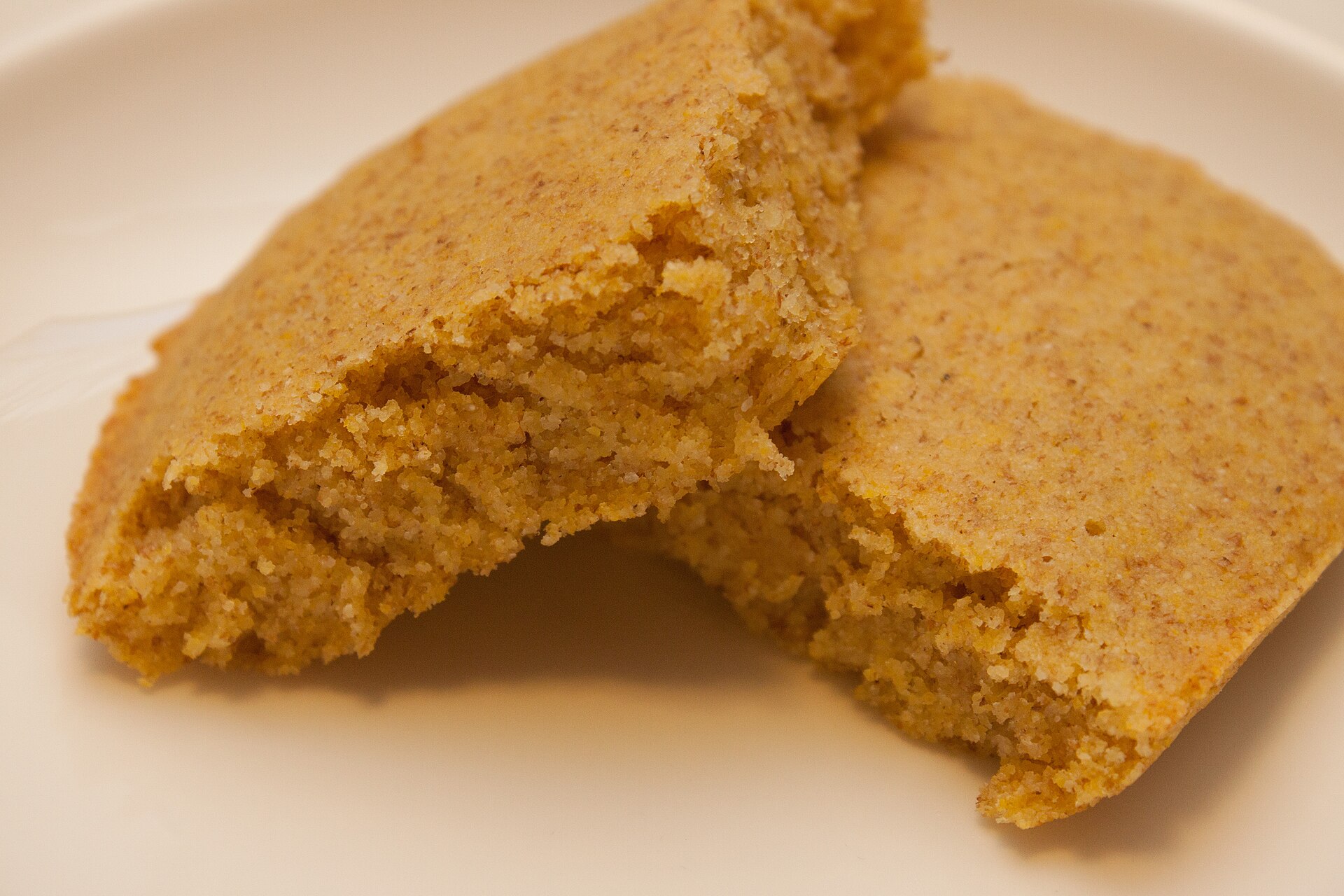 Golden cornbread baked in a skillet, cut into wedges
