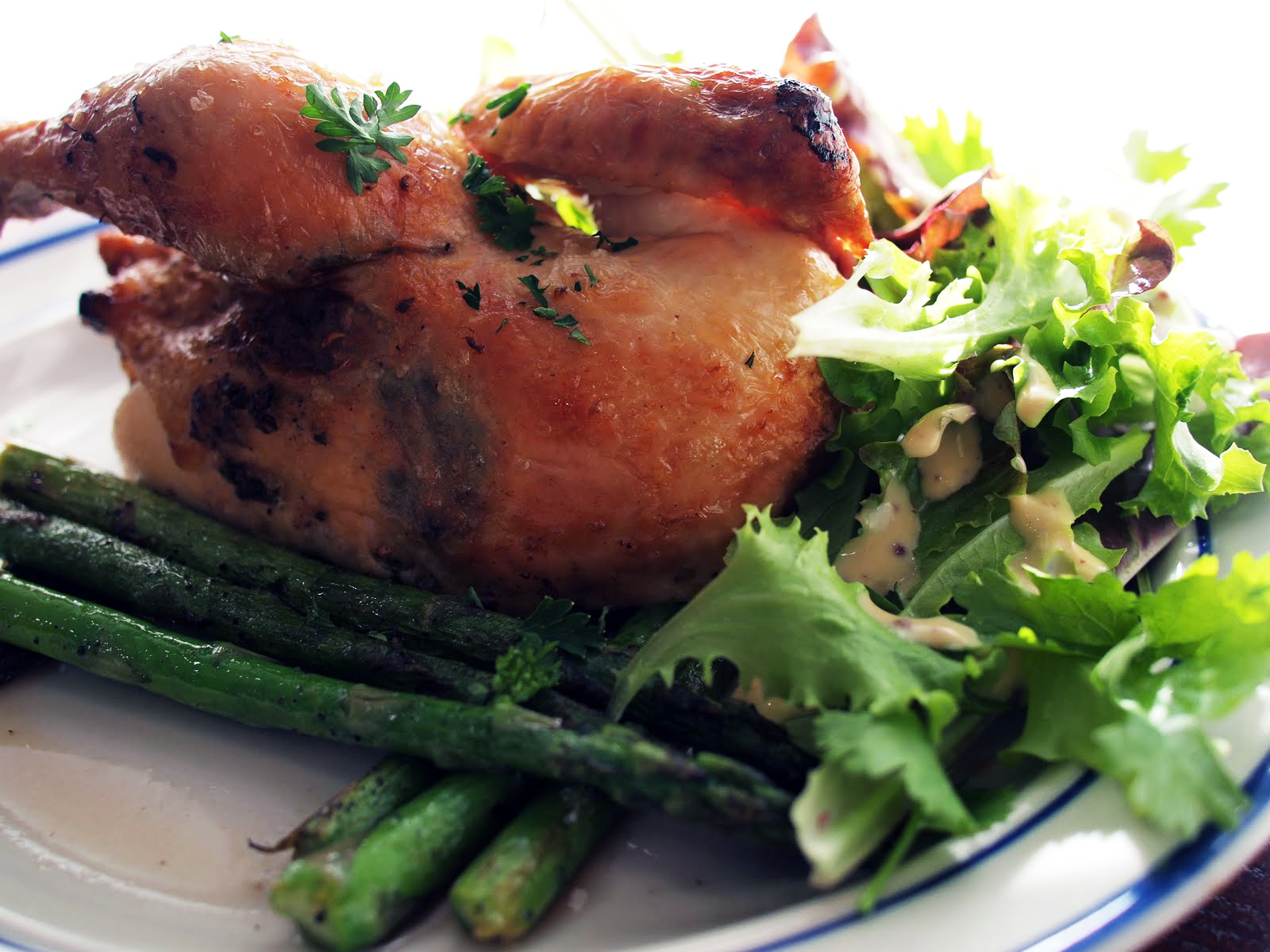 A golden roasted Cornish hen with asparagus