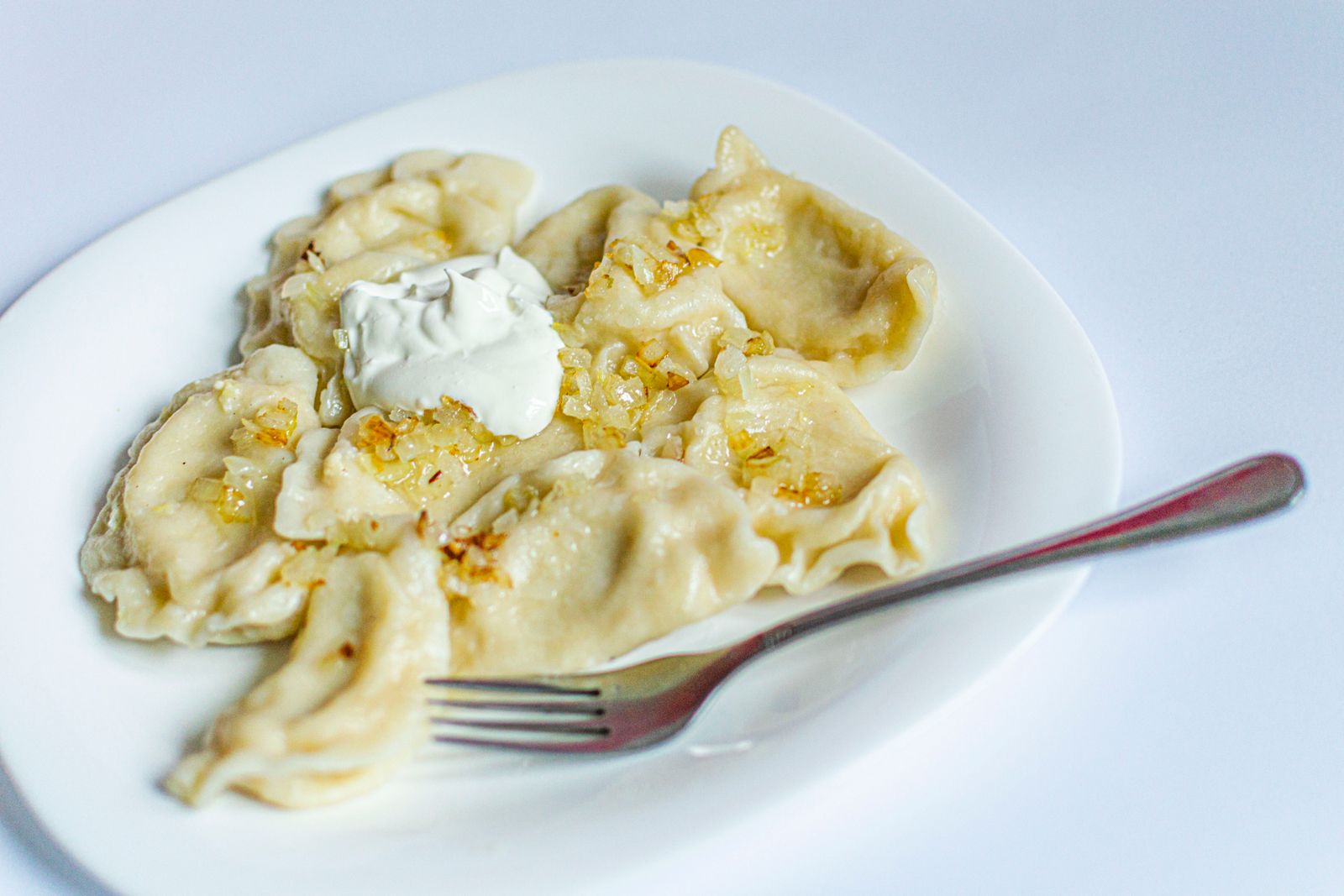 Pierogi with sour cream and golden onions