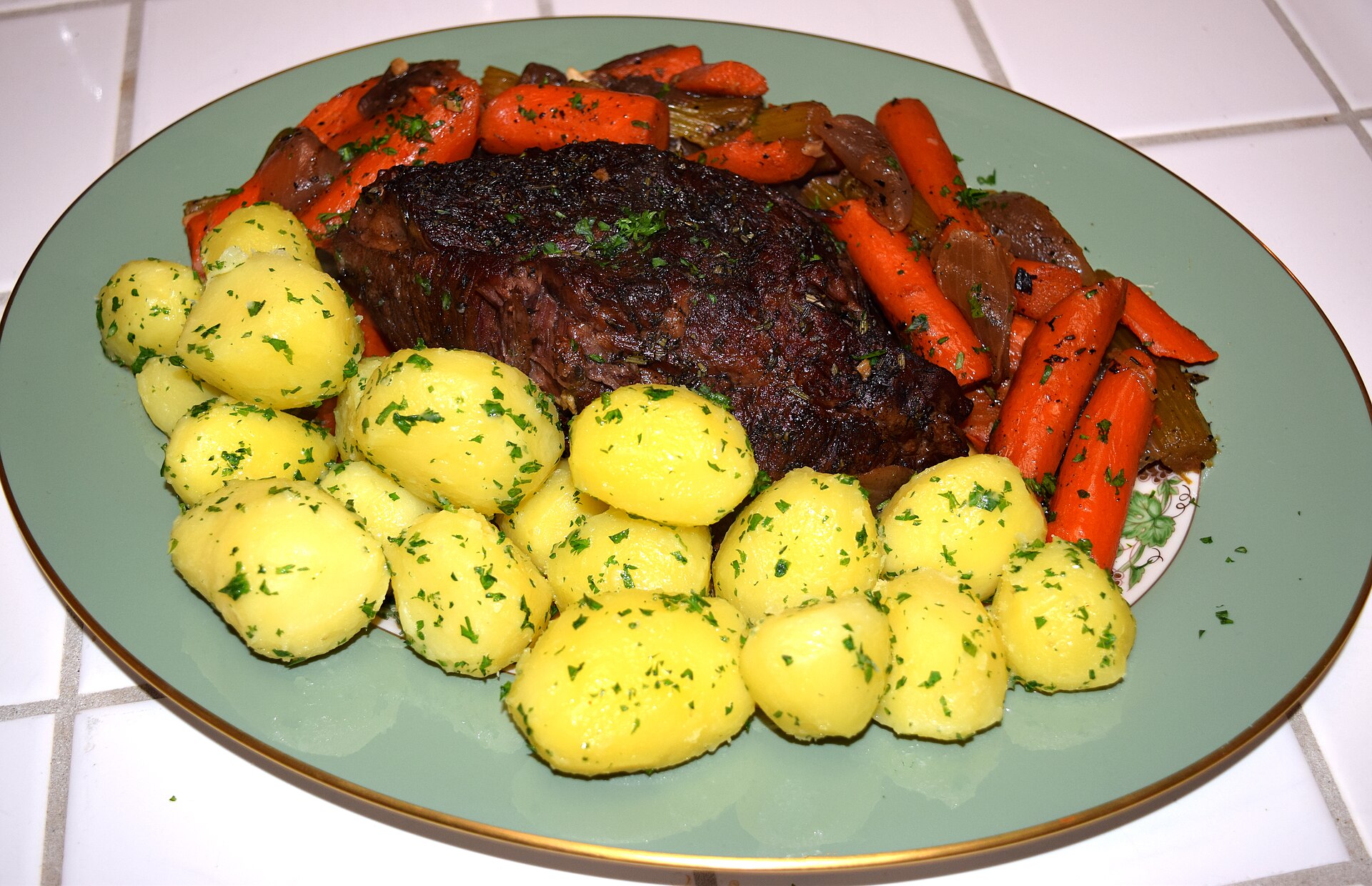 Pot roast with carrots and parsley potatoes on a plate