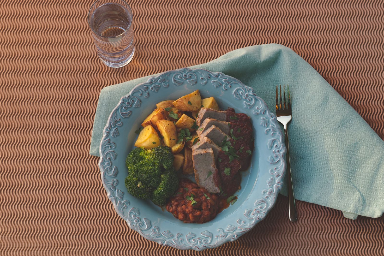 Sliced meatloaf with sauce on a blue plate