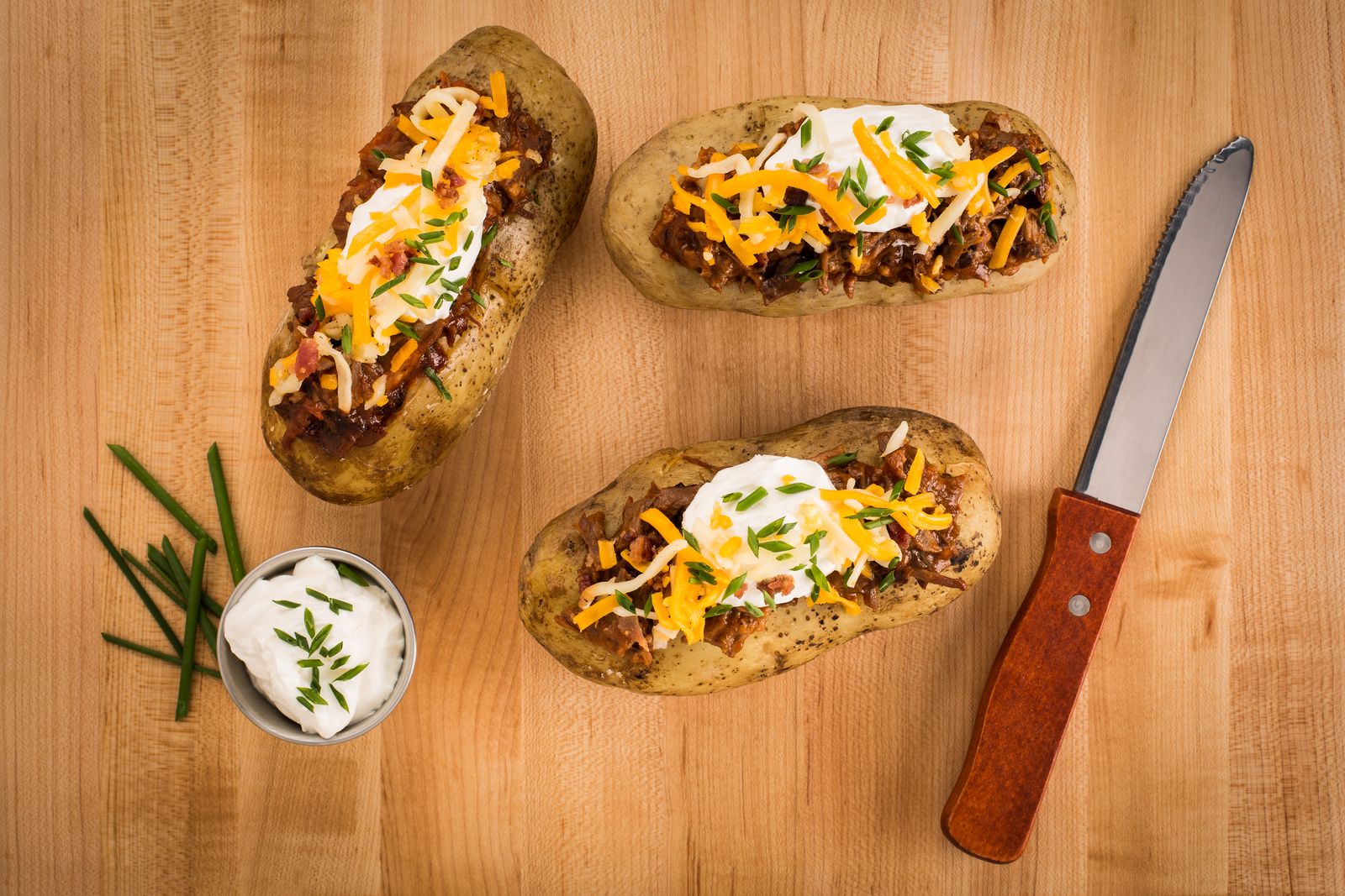 Slow cooker hacks: loaded baked potatoes on a wooden board