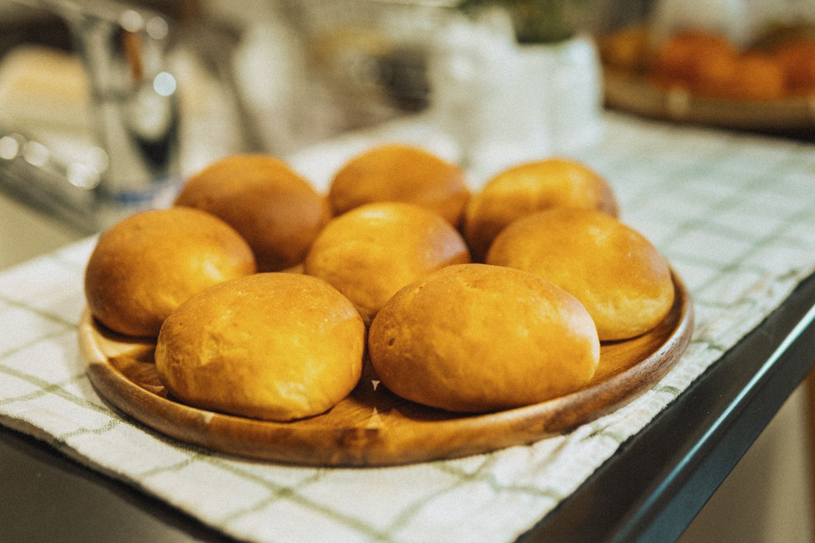 Freshly baked dinner rolls on a wooden plate