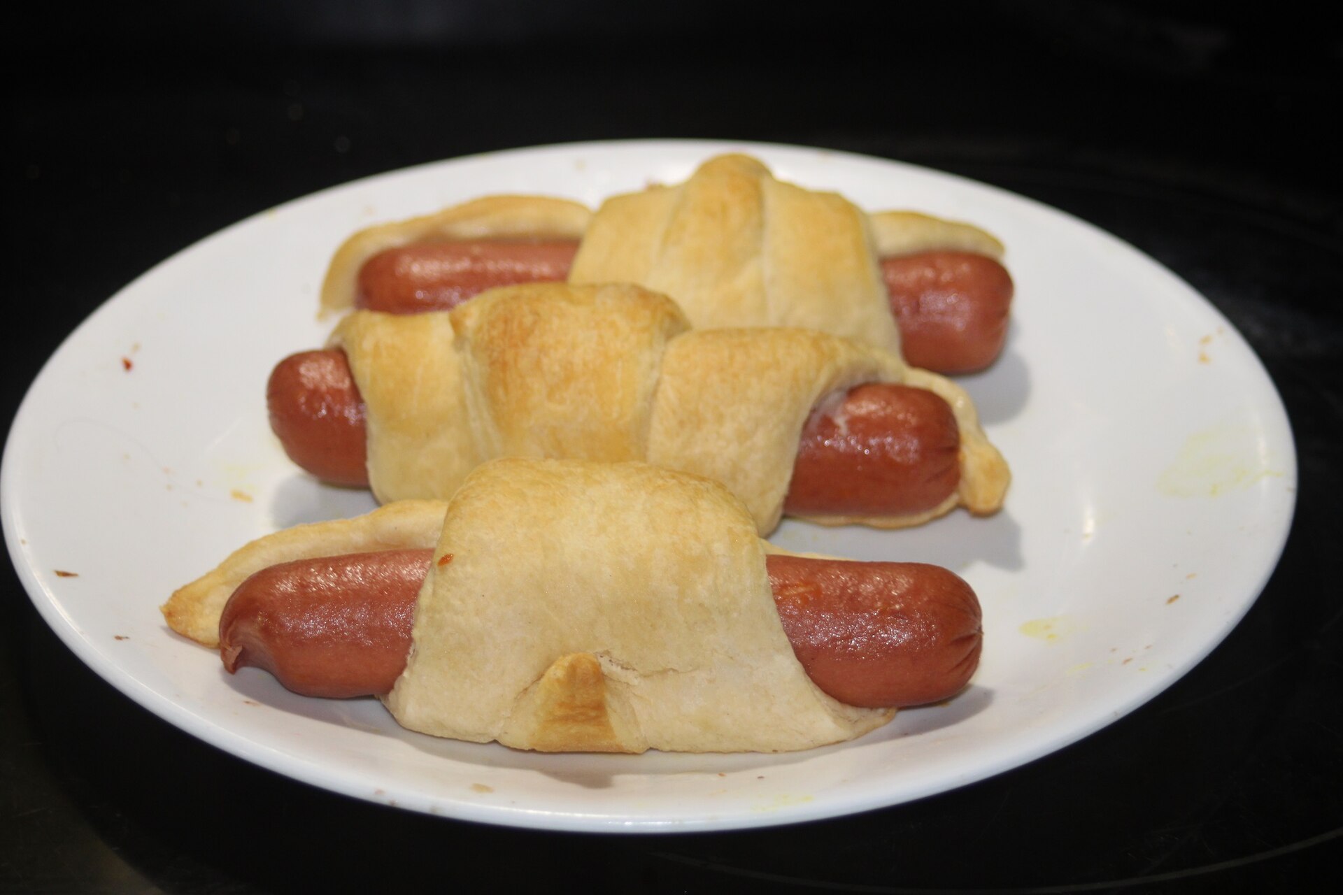 Two-ingredient recipes: homemade pigs in a blanket on a white plate