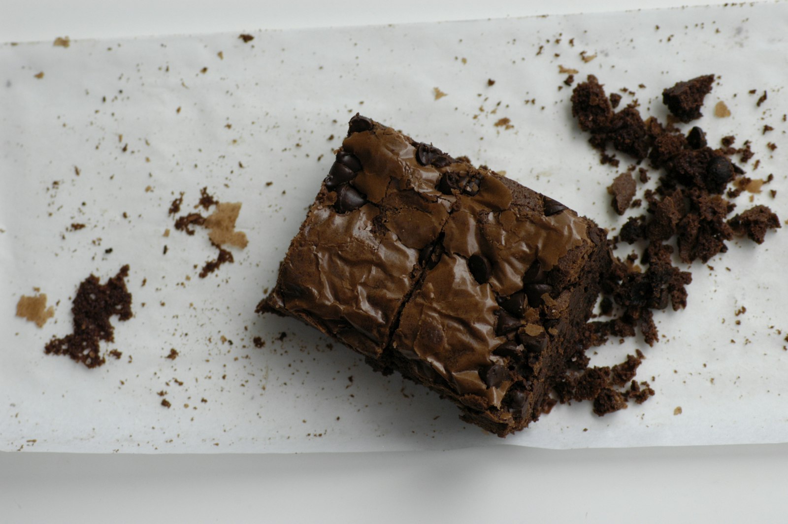 Fudgy chocolate brownie square on parchment