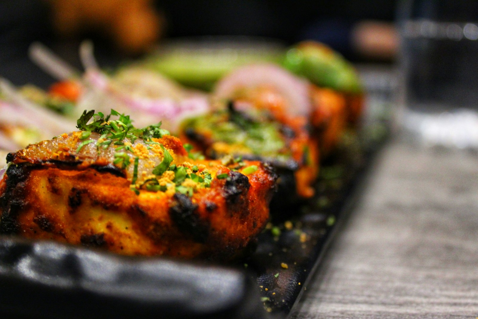 Charred chicken tikka pieces with fresh herbs
