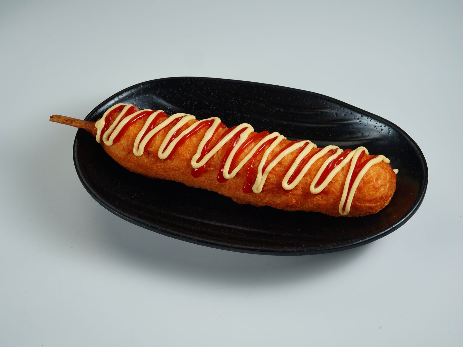Homemade corn dog with ketchup and mustard