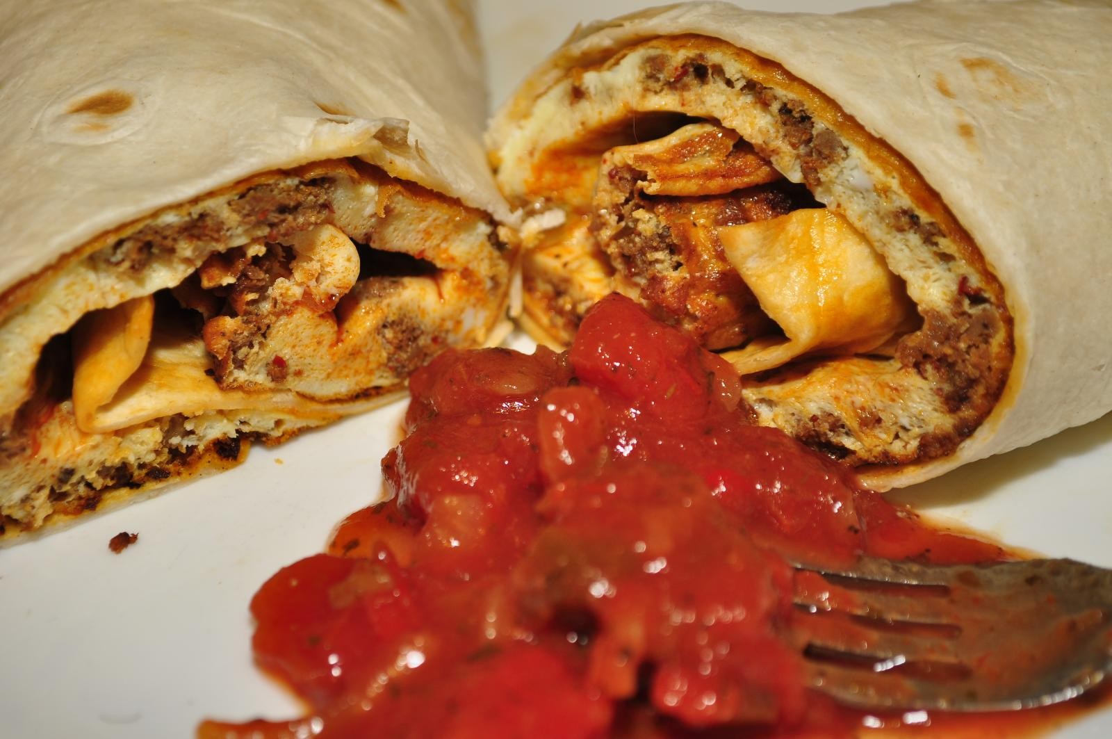 Chorizo and egg wrapped in a flour tortilla with red salsa