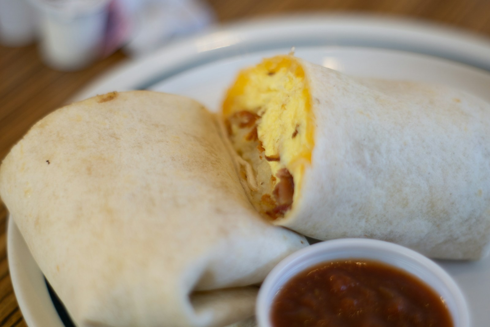 Egg and cheese wrap with a cup of salsa