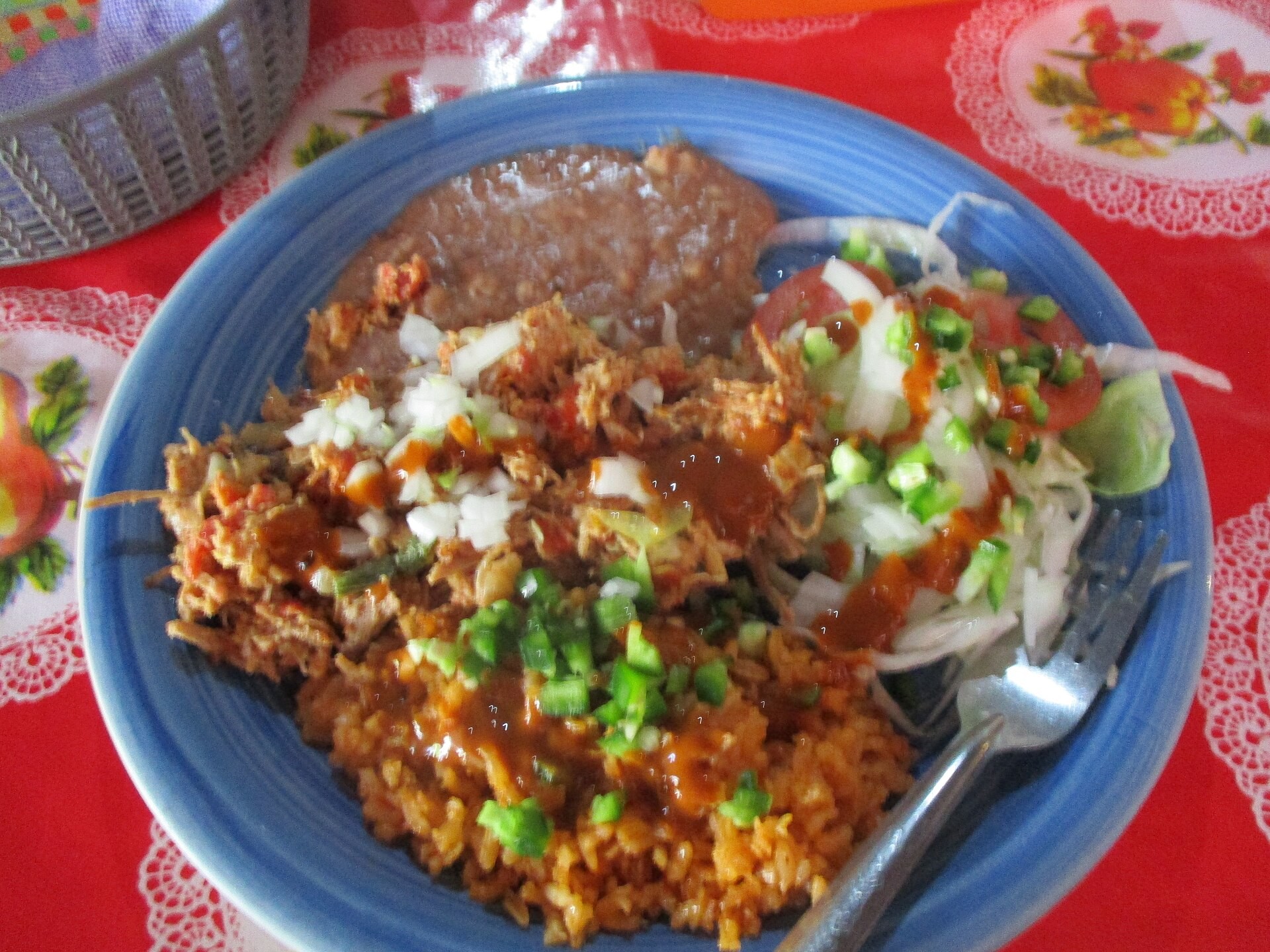 Machaca con huevo with shredded beef, eggs and beans on a blue plate