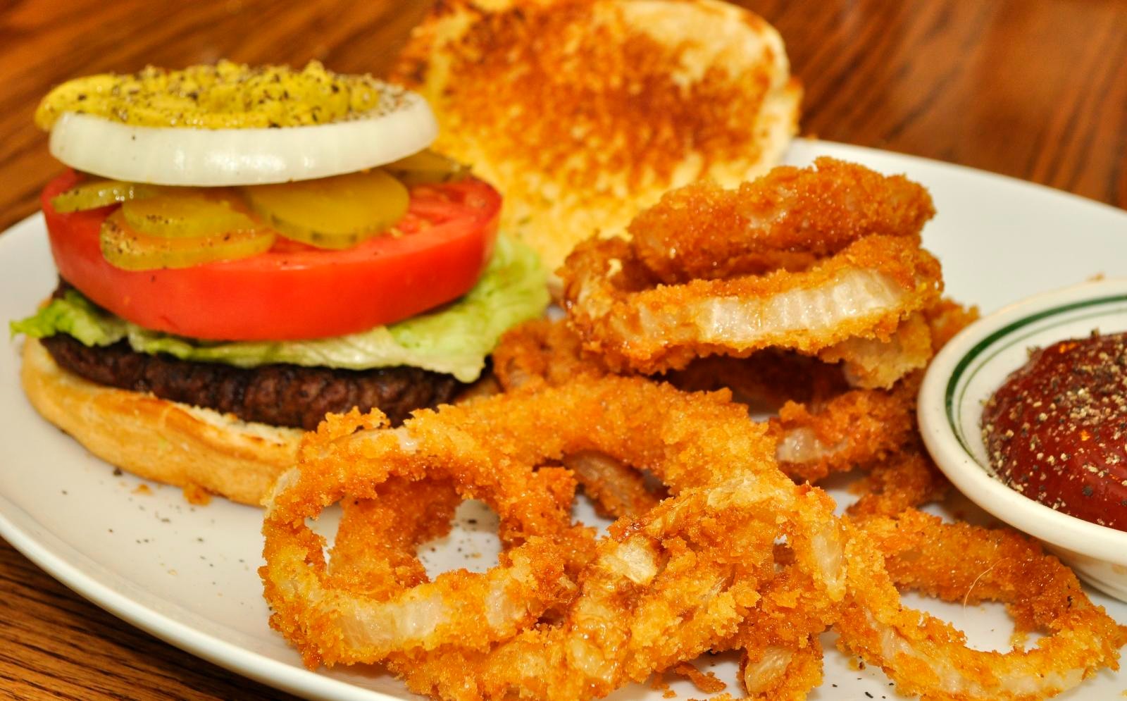 Cheeseburger with a side of crispy onion rings and ketchup