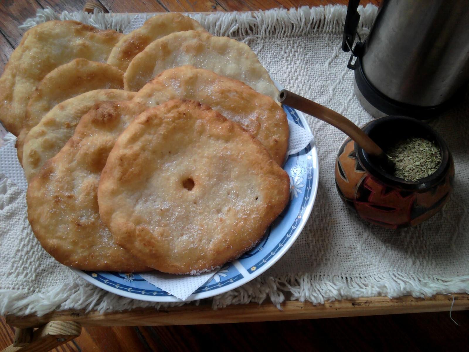 Stack of Argentine torta frita next to a mate cup