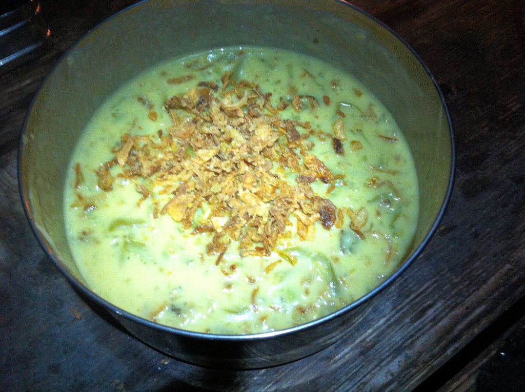 Green bean casserole topped with crispy onions in a round pan