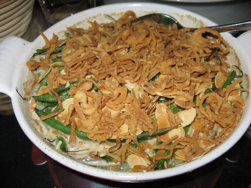 From-scratch green bean casserole with crispy onions in a white baking dish