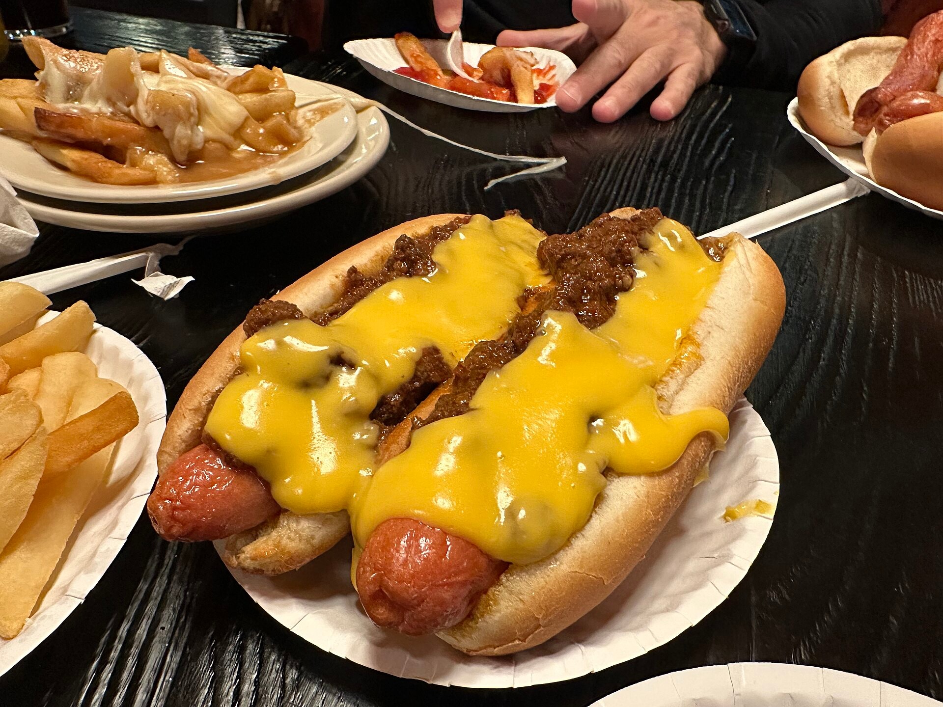 Two chili cheese hot dogs with melted cheese on a plate