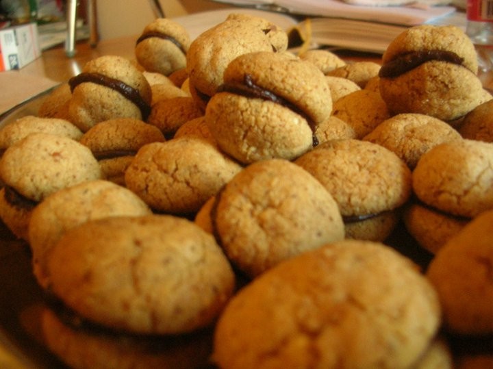 Homemade baci di dama hazelnut sandwich cookies joined with dark chocolate
