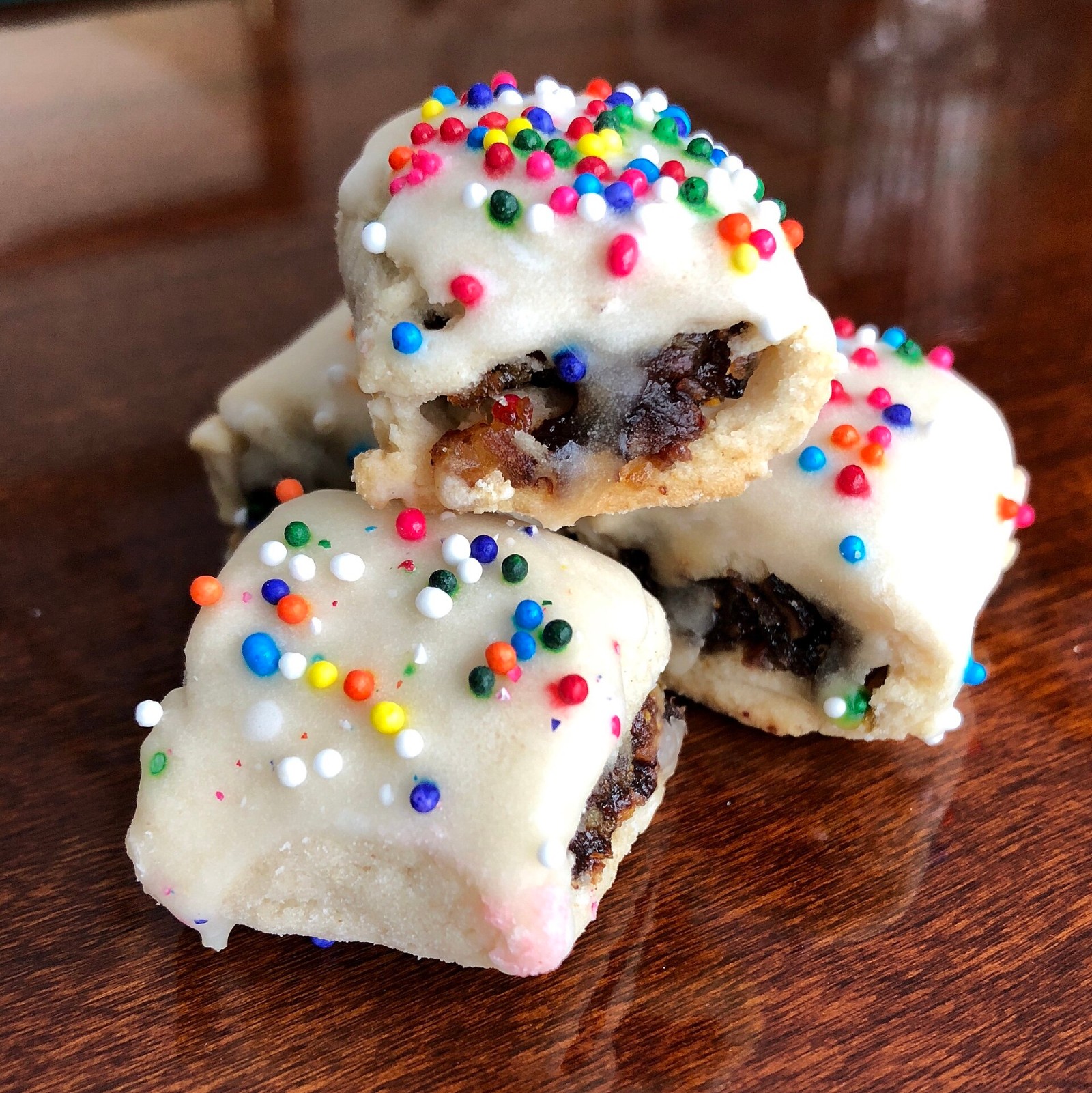 Sicilian cuccidati fig cookies with white icing and rainbow nonpareils