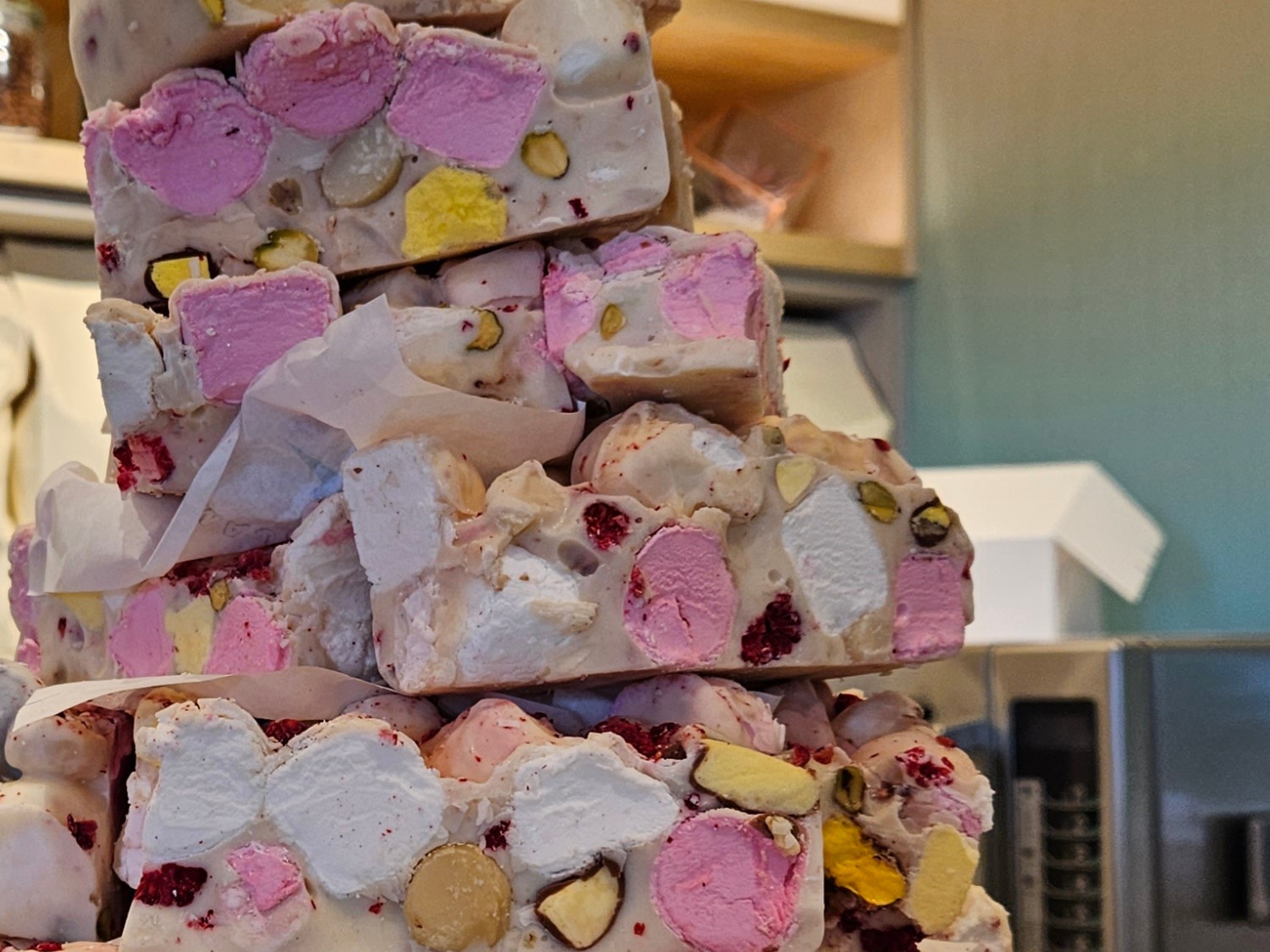 Stacked white chocolate slices with pink marshmallows and pistachios