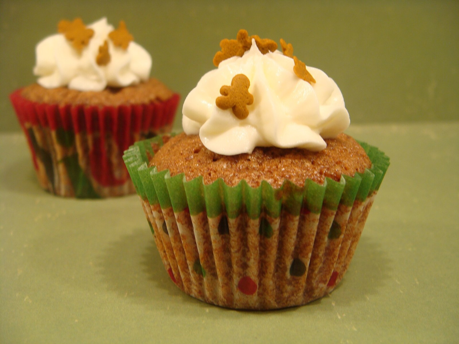 Gingerbread cake in a festive liner with cream frosting and a tiny gingerbread man
