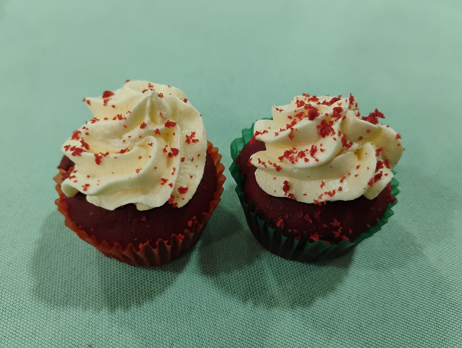 Red velvet cakes with white frosting and red crumbs