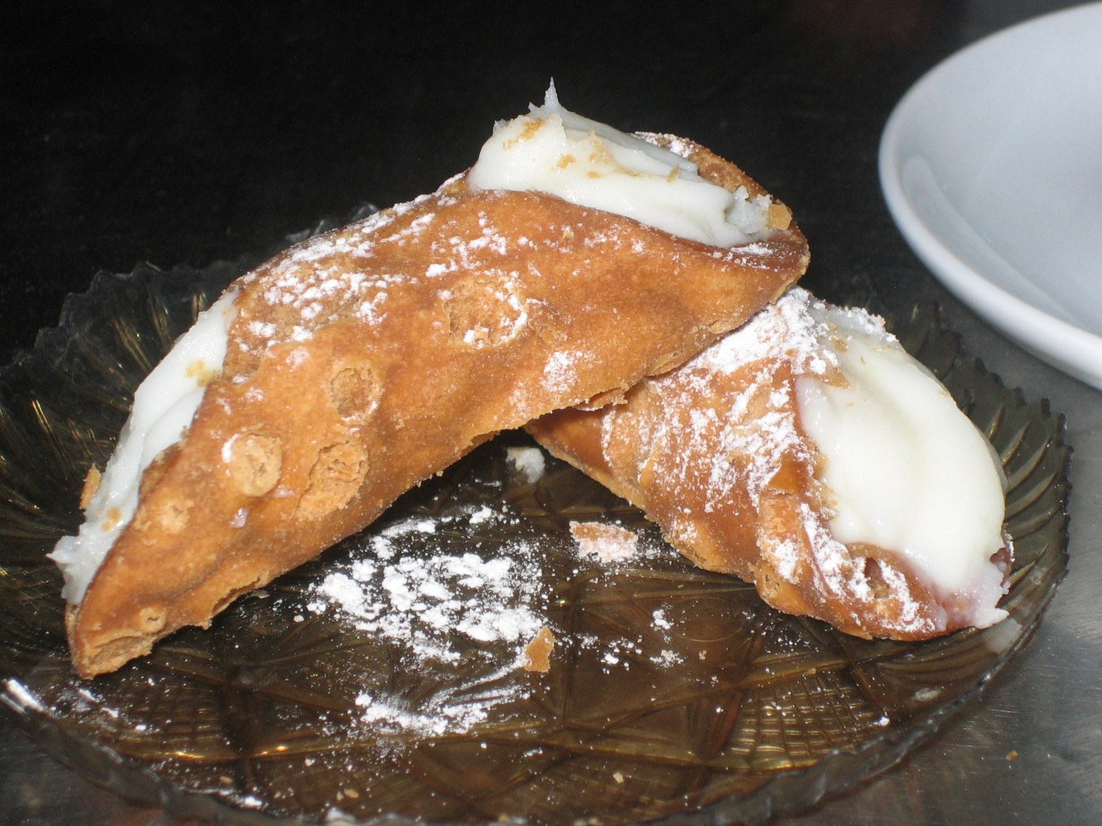 Two cannoli with sweet ricotta filling and powdered sugar