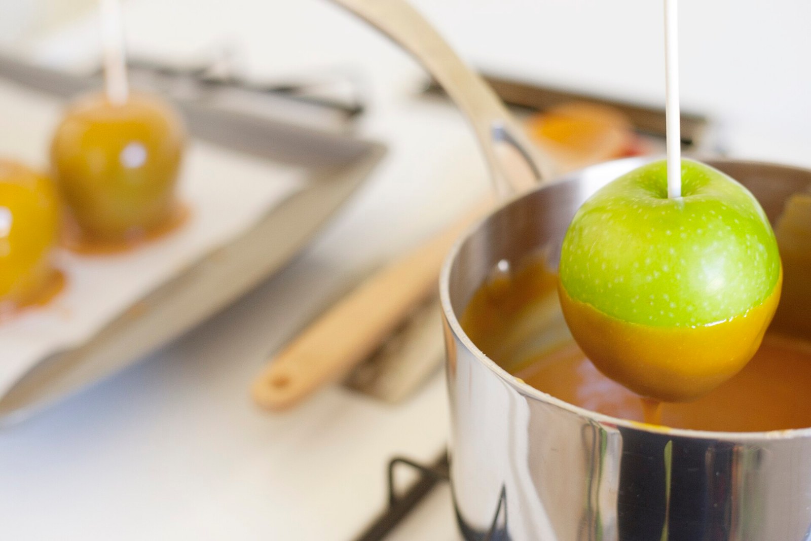 Dessert dips start here: a green apple dipped into a pot of warm caramel