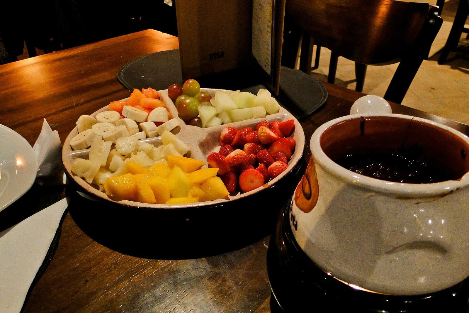 Dessert dips fondue style: a pot of warm chocolate with strawberries, fruit and cake for dipping