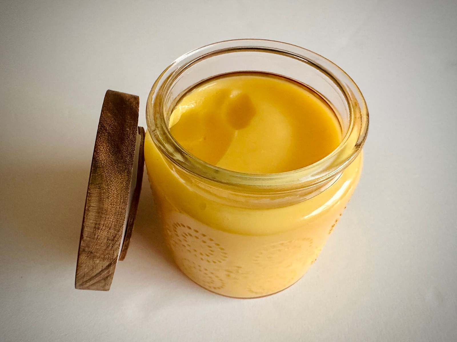 A glass jar of bright yellow homemade lemon curd