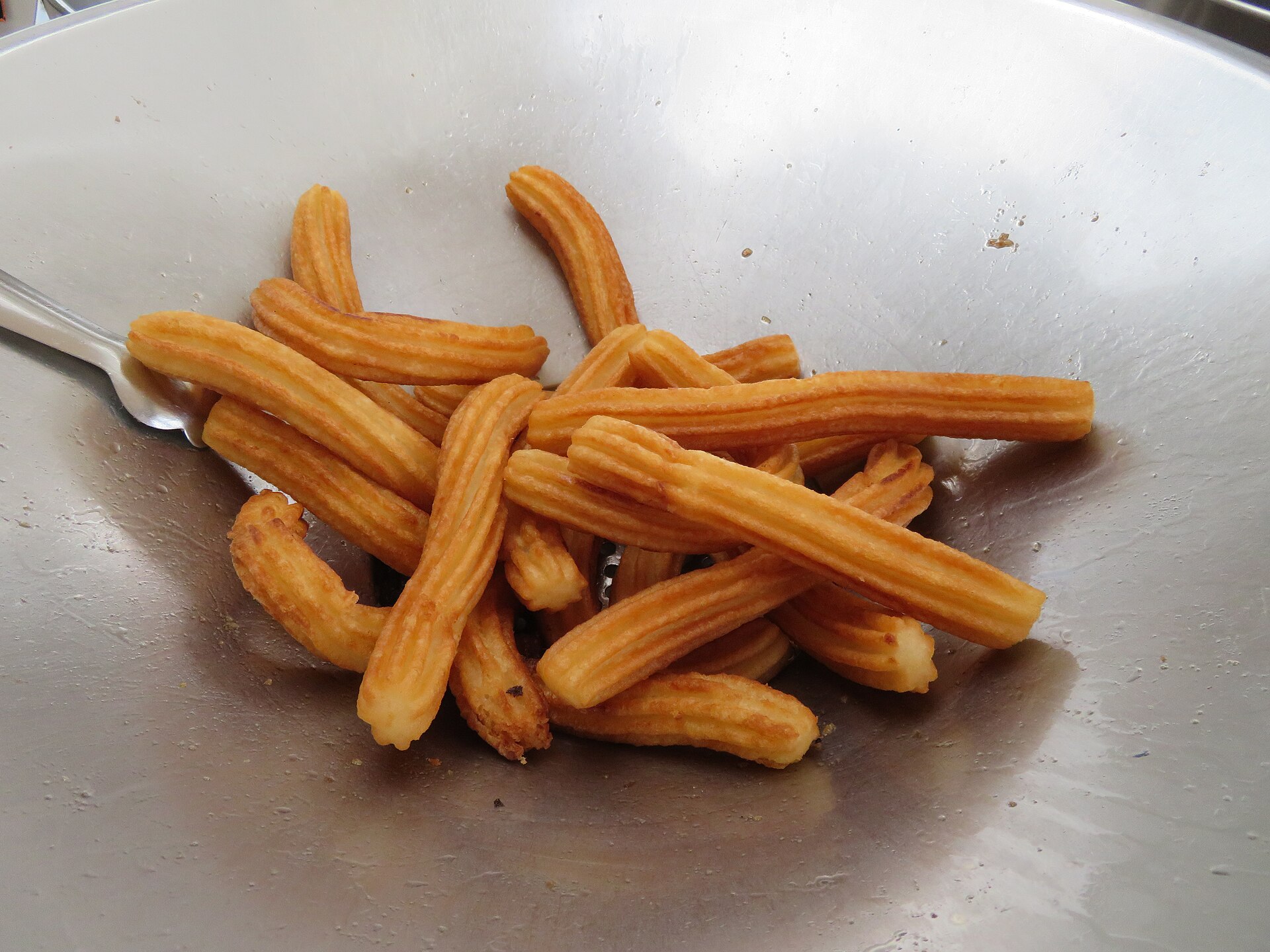 Thin churros sticks piled on a plate
