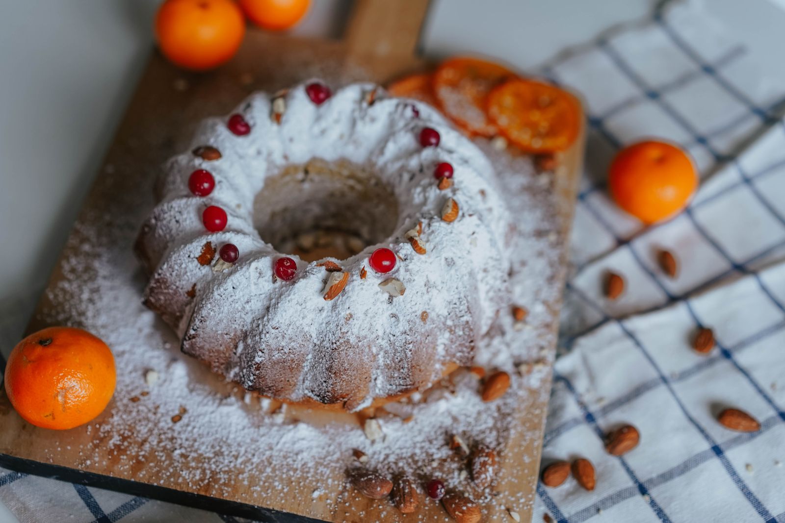 Bundt cake dusted with powdered sugar on a wooden tray