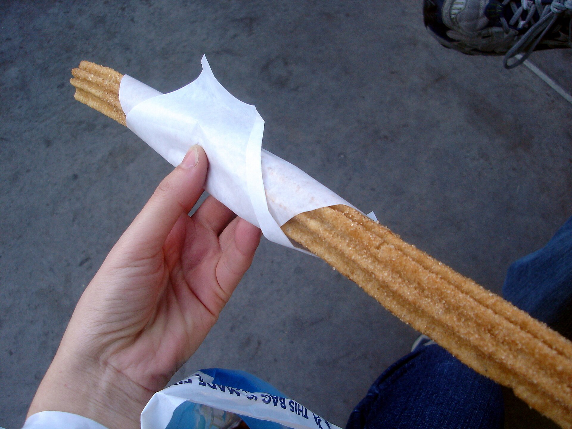 Theme park style churros: a cinnamon sugar churro in a paper wrap