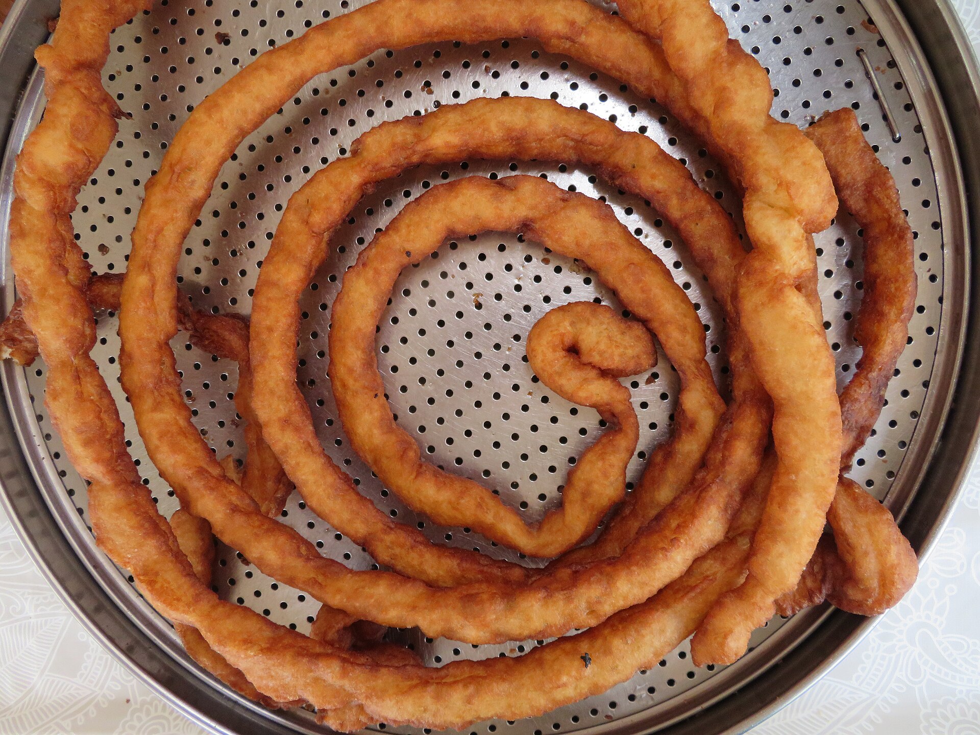 A long spiral of fried churros dough at a Spanish churreria