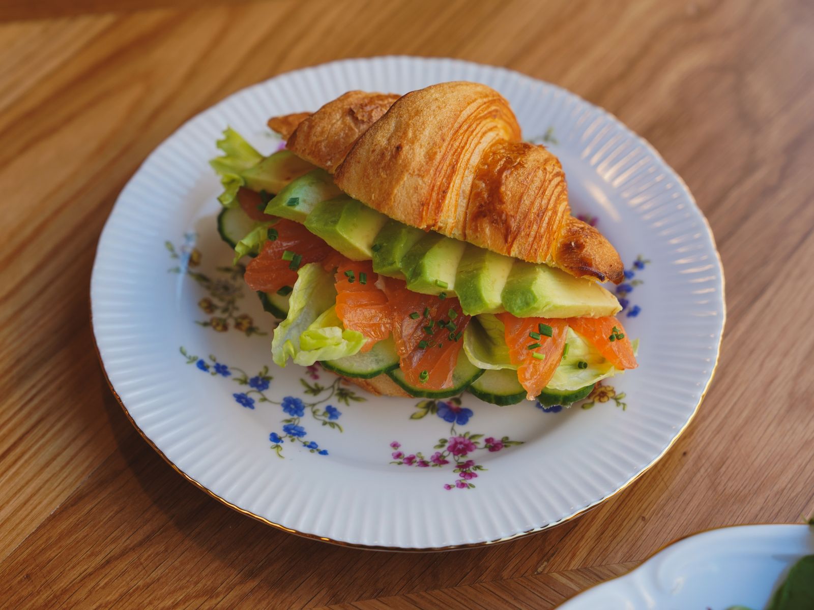 Croissant recipes: smoked salmon and cucumber croissant on a floral plate