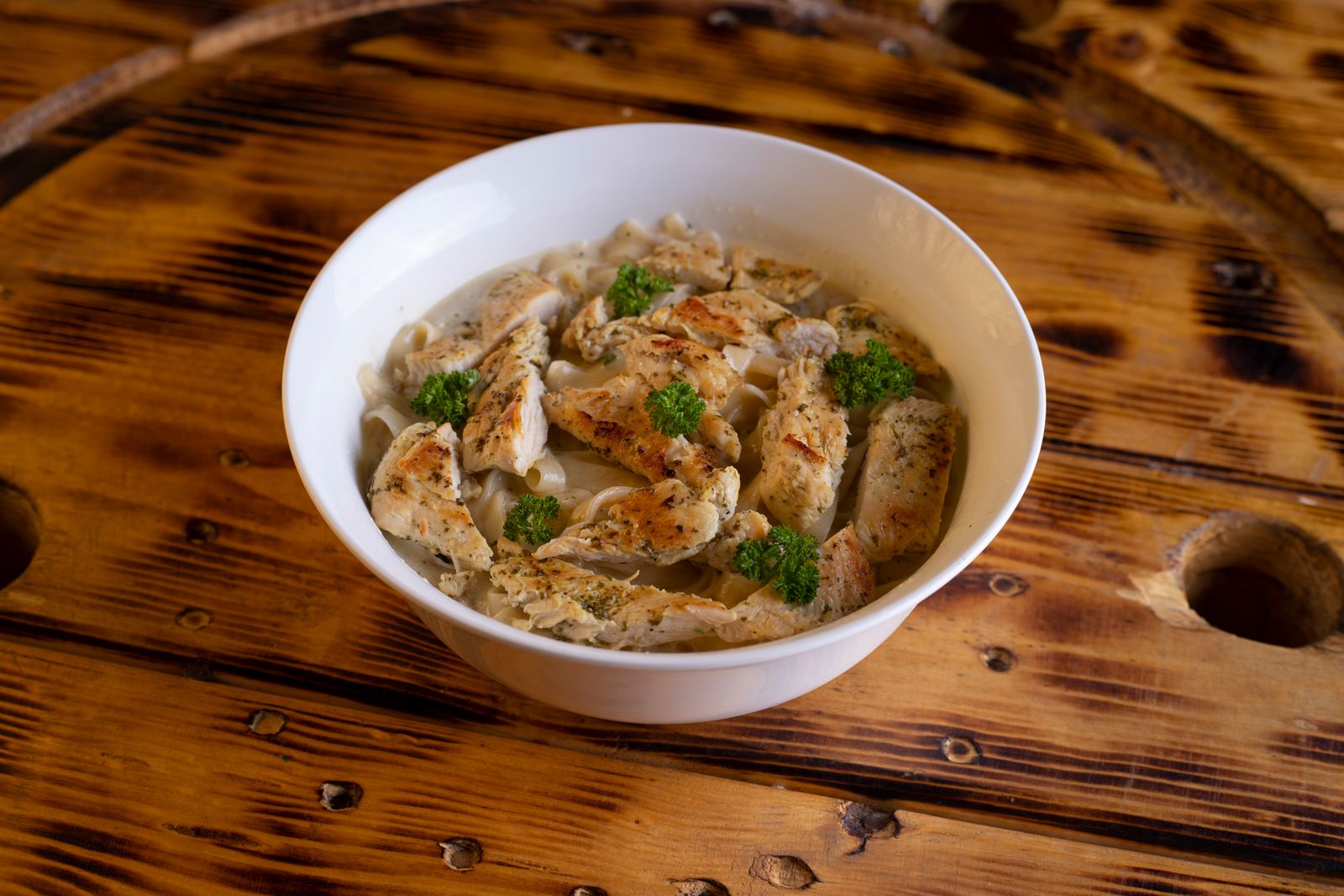 Broccoli pasta in a creamy cheese sauce in a white bowl