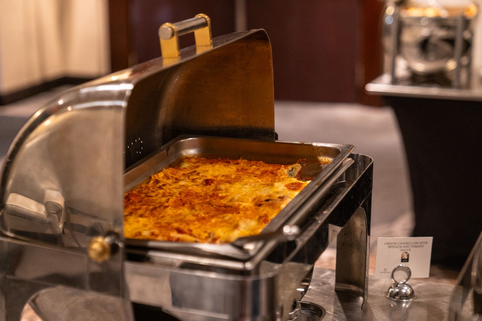 Cheesy pasta casserole in a buffet warmer at a potluck