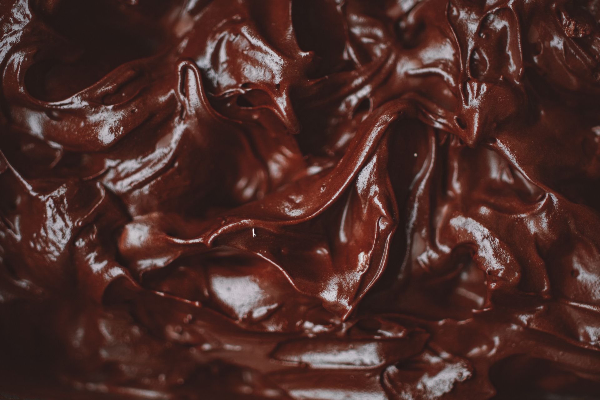 Silky dark dessert close up with a glossy swirl