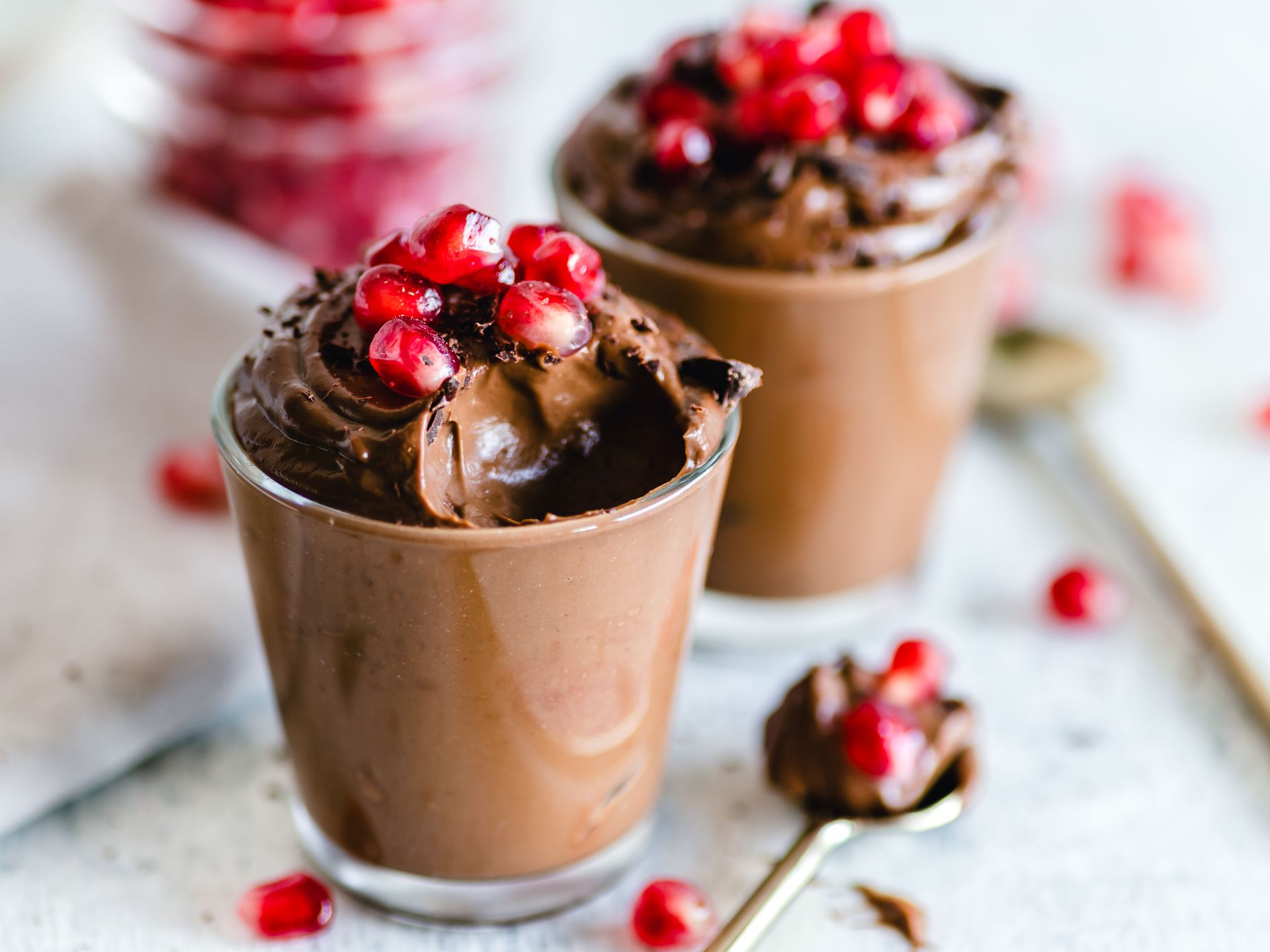 Dessert cups topped with red fruit and cream